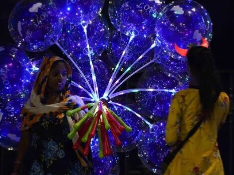 A woman sells partygoers balloons in India. Picture: Getty Images