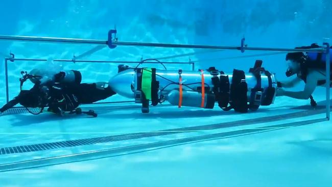 Divers test the Musk “mini-sub’’ underwater in an LA pool.