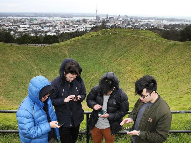 Gamers search for Pokemon on the top of Mount Eden in Auckland, New Zealand. Picture: Getty