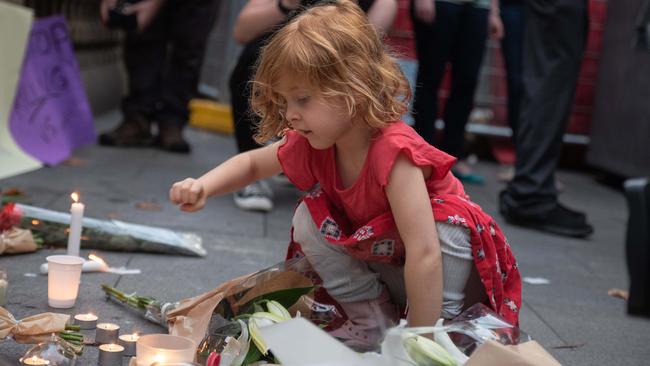 Five-year-old Olivia Corbiau lays a candle at tonight’s Town Hall vigil for murdered dentist Preethi Reddy. Picture: Flavio Brancaleone)