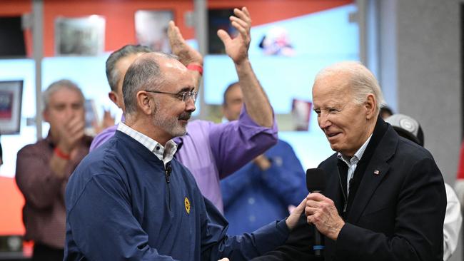 Joe Biden shakes hands with UAW president Shawn Fain (L) during a visit to a United Auto Workers phone bank in Detroit. Picture: AFP.