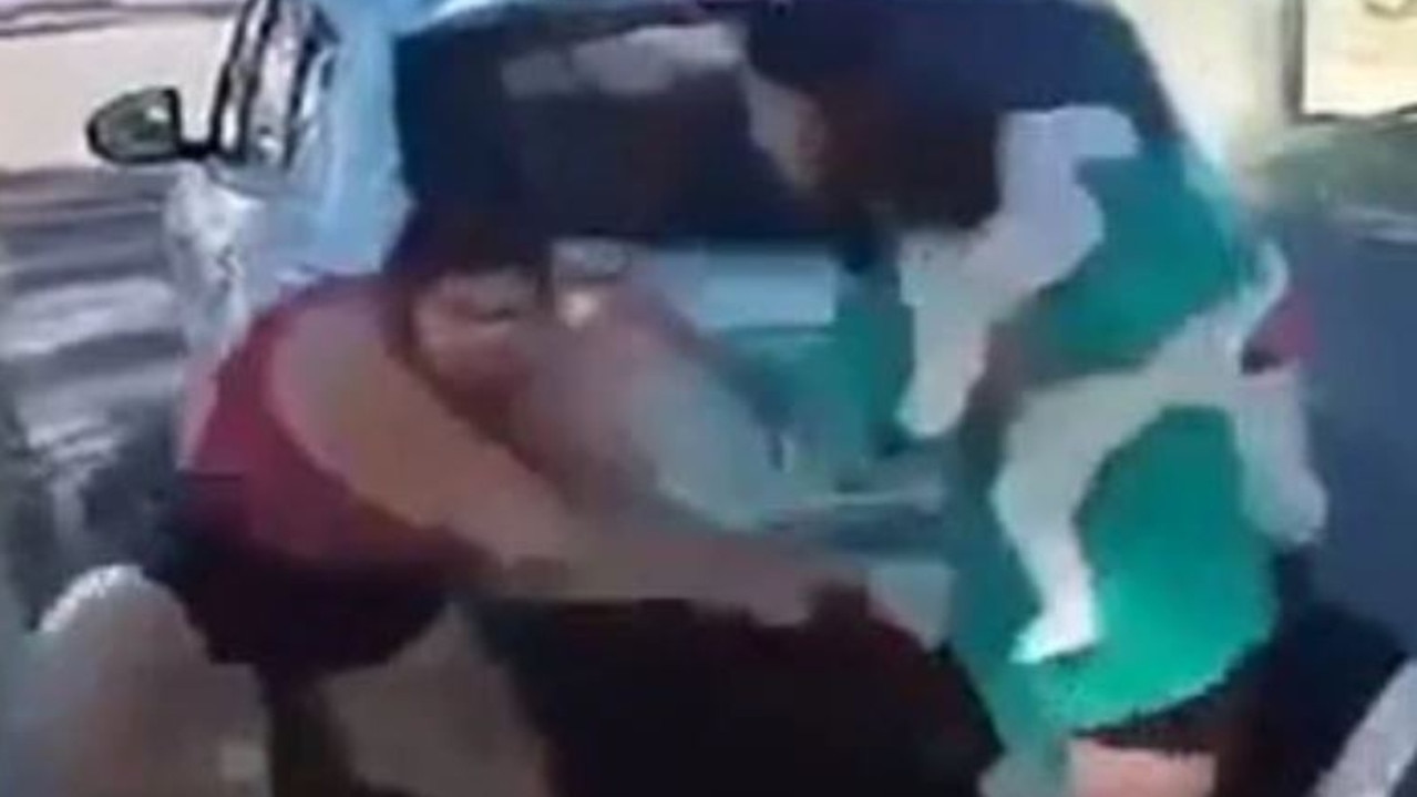 Woman holding baby tries to stop brawl