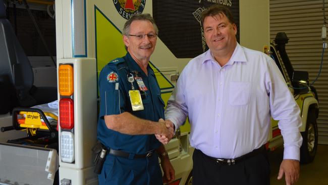 Officer in charge Gary Cotterill receives a Toyota 4WD Modular Ambulance from Burnett MP Stephen Bennett at the Childers Ambulance Station. Photo: File