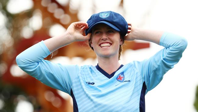 Claire Moore putting on her debut cap during the WNCL match between NSW and the ACT at North Sydney Oval in February.