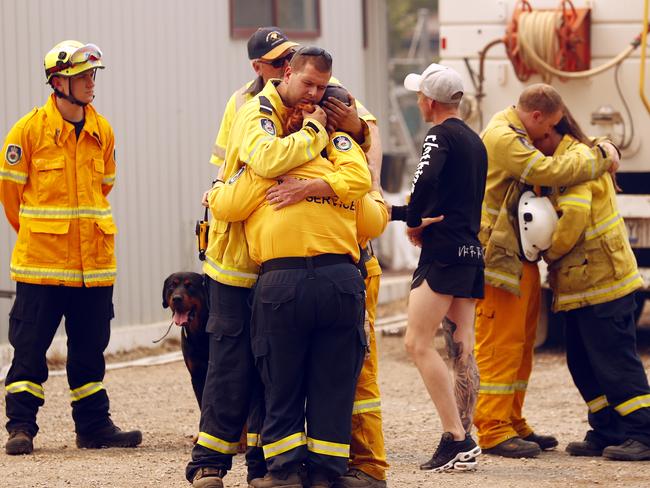 RFS members from Balmoral hug each other after rumours of property loss filters through. Picture: Sam Ruttyn