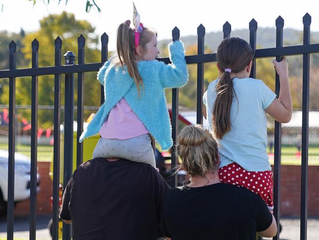 Storm fans watch their stars through a fence during a training session.