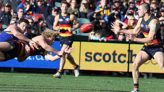 Dynamic duo ... Rory Sloane gets a handball to Brad Crouch, despite being caught in a tackle. Picture: Sarah Reed.