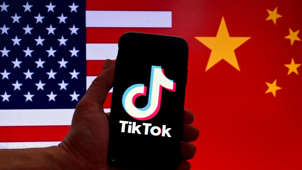 (FILES) In this photo illustration the social media application logo for TikTok is displayed on the screen of an iPhone in front of a US and Chinese flag background in Washington, DC, on March 16, 2023. The US House of Representatives on April 20, 2024, passed a bill that would force TikTok to divest from its Chinese parent company ByteDance or face a nationwide ban in the United States, where it has around 170 million users. (Photo by OLIVIER DOULIERY / AFP)
