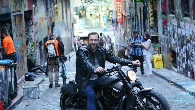 Sometimes AFL footballers can be found on their motorbikes in Hosier Lane. Here’s Travis Cloke on a Harley Davidson. Picture: Wayne Ludbey