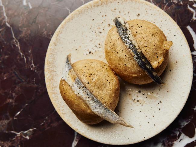 Sicilian fried doughnuts filled with fontina cheese fondue and draped in white anchovy is a mouthful in many ways. Picture: Parker Blain.