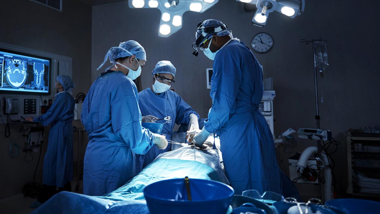 ****Must credit: iStock****.Shot of a team of surgeons performing a surgery in an operating room. Medical Supplies, Emergency Services, Science and Technology, Women, Men, Group Of People, Part Of A Series, Surgical Equipment, Protective Glove, Medical Procedure, Female Doctor, Surgical Cap, Emergency Room, Protective Mask - Workwear, Surgical Mask, Standing, Working, Moving Activity, Expertise, Cooperation, Teamwork, Concentration, Healthcare And Medicine, Science, Selective Focus, Horizontal, Color Manipulation, Scientist, Surgeon, Doctor, Nurse, Medical Occupation, Healthcare Worker, Professional Occupation, Occupation, Patient, People, Reflection, Operating Room, Hospital, Medicine, Intensive Care Unit, Medical Equipment, Computer Monitor, Equipment, Surgery, Eyewear, Protective Workwear, Specific Clothing, Male Doctor, Team, Colleague