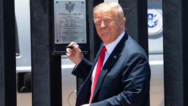 US President Donald Trump signs a plaque as he participates in a ceremony commemorating the 200th mile of border wall at the international border with Mexico in San Luis, Arizona. Picture: AFP