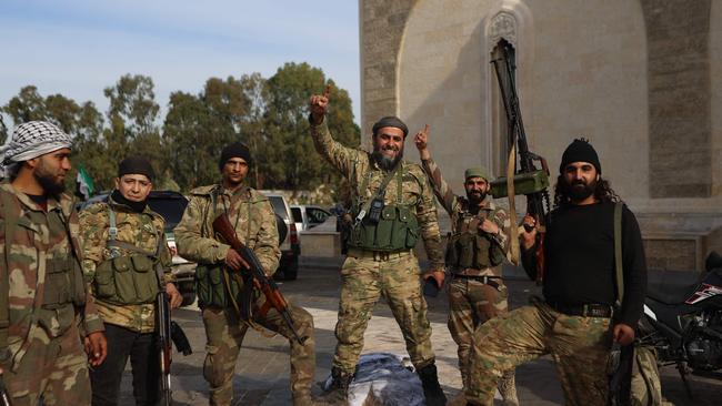 Rebel fighters outside the mausoleum of Syria's late president. Hafez al-Assad. Picture: Aaref Watad / AFP