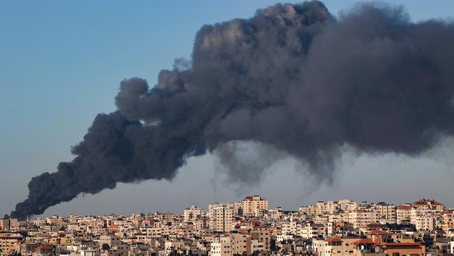 A plume of heavy black smoke rises above buildings in Gaza City from a fire caused by Israeli air strikes on May 15. Picture: AFP