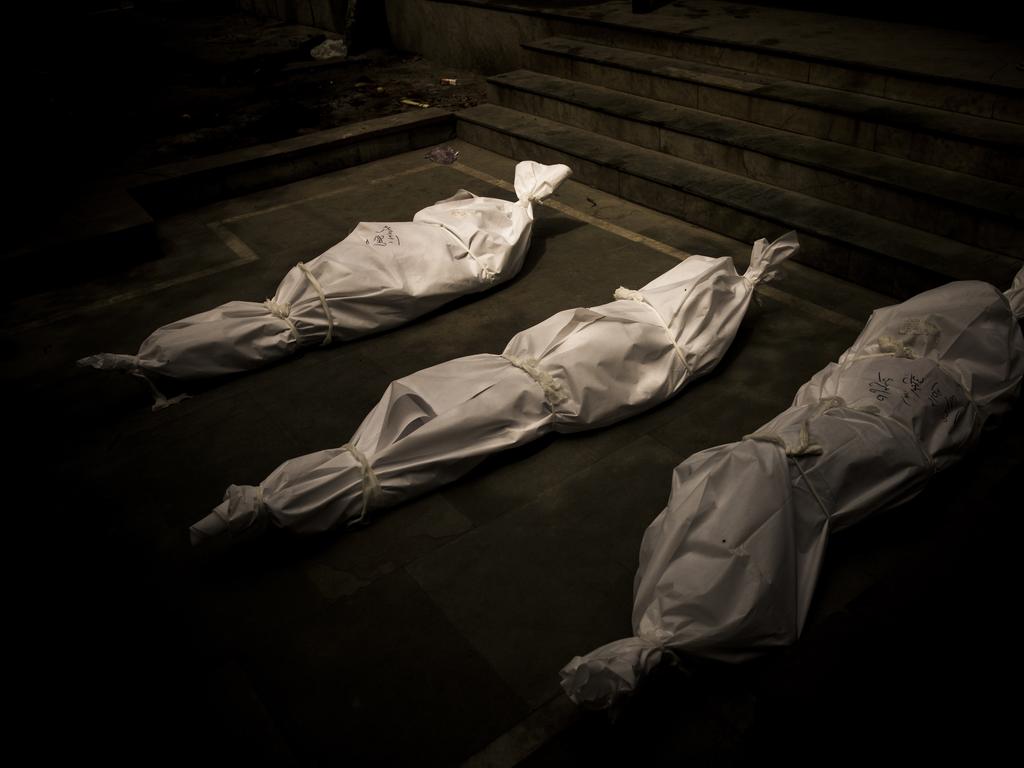 Dead bodies wrapped in protective covers are kept on the ground waiting to be cremated in India. Picture: Anindito Mukherjee/Getty Images