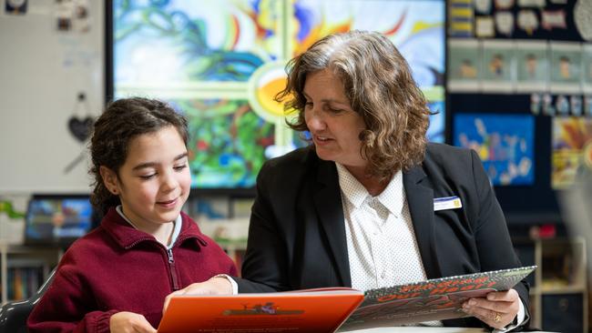 Acting principal Monique Egan reads with Liz Castro at St Vincent's Primary School in Canberra, where most students did well in this year’s NAPLAN tests. Picture: Martin Ollman