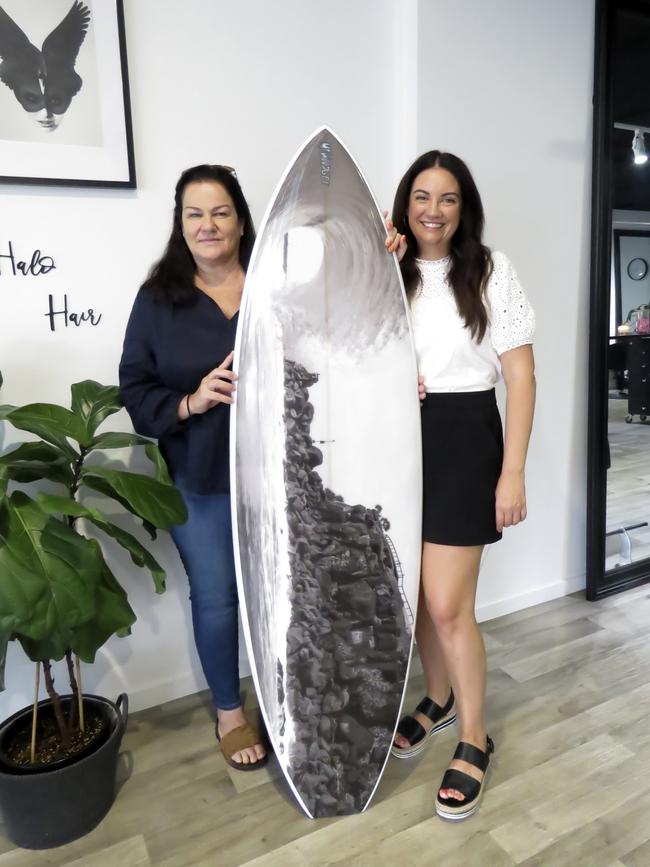 Judy Littler (left) won a custom made Mt Woodgee surf board, among other prizes, after buying tickets for a fundraiser to support wildlife organisations supporting bushfire affected animals. Rachel Hannah (right) was just one of 12 salons across the Tweed and Gold Coast who organised the event.