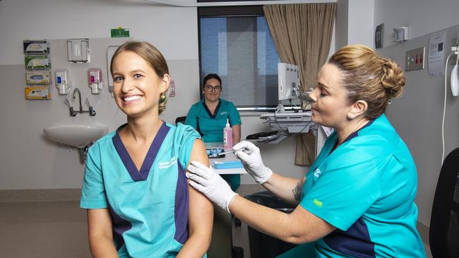 Registered nurse Zoe Park receiving the first Covid-19 Pfizer vaccine from clinical nurse consultant Kellie Kenway at Gold Coast University Hospital. Photo by Nigel Hallett