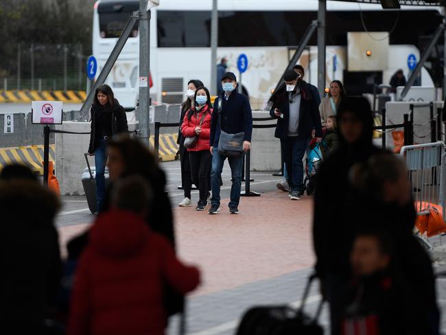 Passengers exit the port after disembarking with others from the Costa Smeralda cruise ship docked at Civitavecchia, 70km north of Rome, after the ship was placed in lockdown due to suspected coronavirus. Picture: Filippo Monteforte/AFP