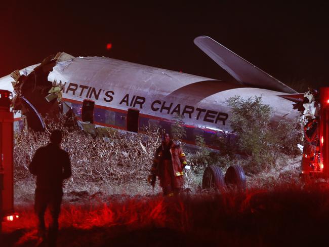 South African paramedics and emrgency services gather at the scene of a plane crash on July 10, 2018 at Wonderboom, on the outskirts of Pretoria, South Africa.  Nineteen people were injured when a plane crashed on July 10, in a grassy area of the South African capital Pretoria, emergency services said, giving a preliminary toll. "Medics from ER24 and other services are at the scene of a plane crash at Wonderboom in Pretoria," Russell Meiring, spokesman for the ER24 medical service said. "We have 19 injured casualties ranging from minor to critical injuries at this stage and no confirmed fatalities." / AFP PHOTO / STRINGER