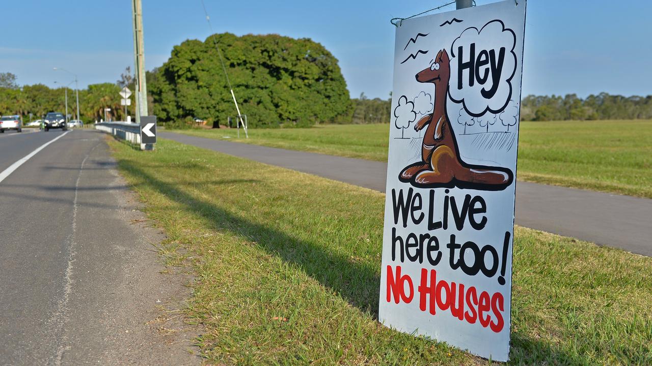 Protest signs around Twin Waters West and flood indication sign at 7ft