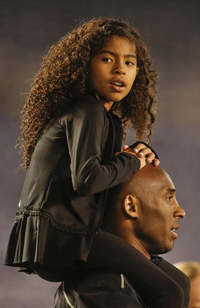 Gigi sits on the shoulders of her father, Kobe. Picture: Lenni Ignelzi/AP