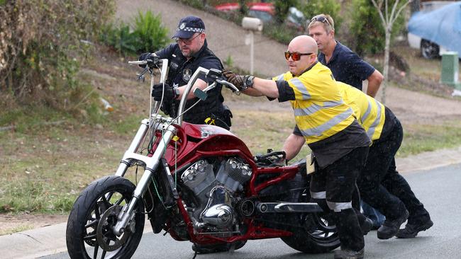 A motorcycle is taken from the scene at Kumnick Street, Upper Coomera where there was a shooting last night involving a Rebels bikie Gokhan Turkyilmaz. Pics Adam Head