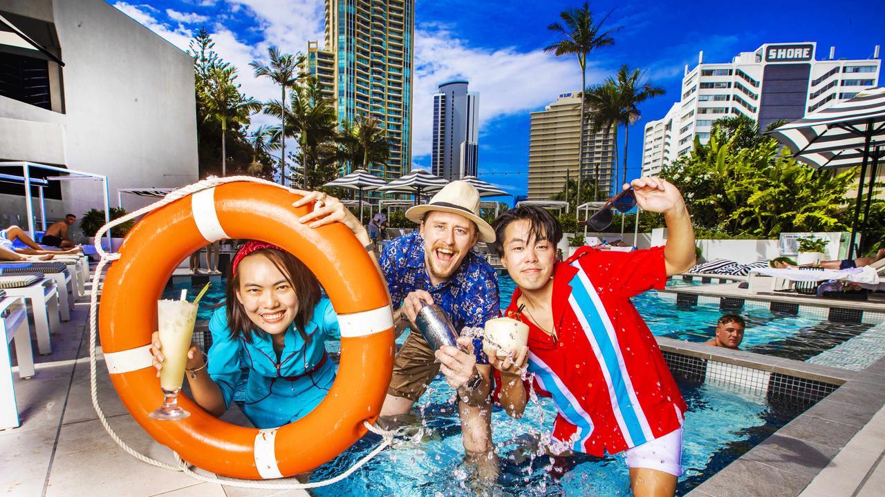 QT Gold Coast workers Anna Nguyen, Cameron Pollard and Akira Nishigaki celebrating the return of international travel. Picture: Nigel Hallett