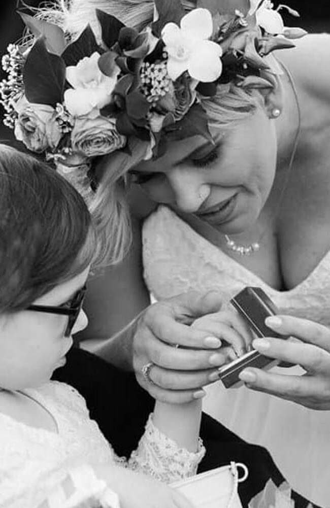 Paige Skarratts hands the ring to her mother Tania during their wedding ceremony.