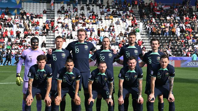 Masked Socceroos skipper Mat Ryan (back far left) and teammates gather before their win over Syria. Picture: HECTOR RETAMAL / AFP