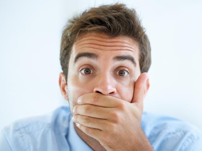 Portrait of a young businessman covering his mouth with his hand, generic hand over mouth