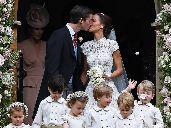 Pippa Middleton (R) kisses her new husband James Matthews, with bridesmaids, including Britain's princess Charlotte (L) and pageboys, including Britain's Prince George (2R). Picture: AFP