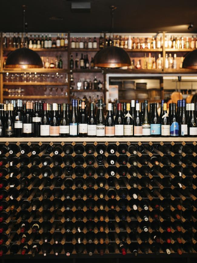 Local wines line the racks at Orange’s Charred Kitchen &amp; Bar.