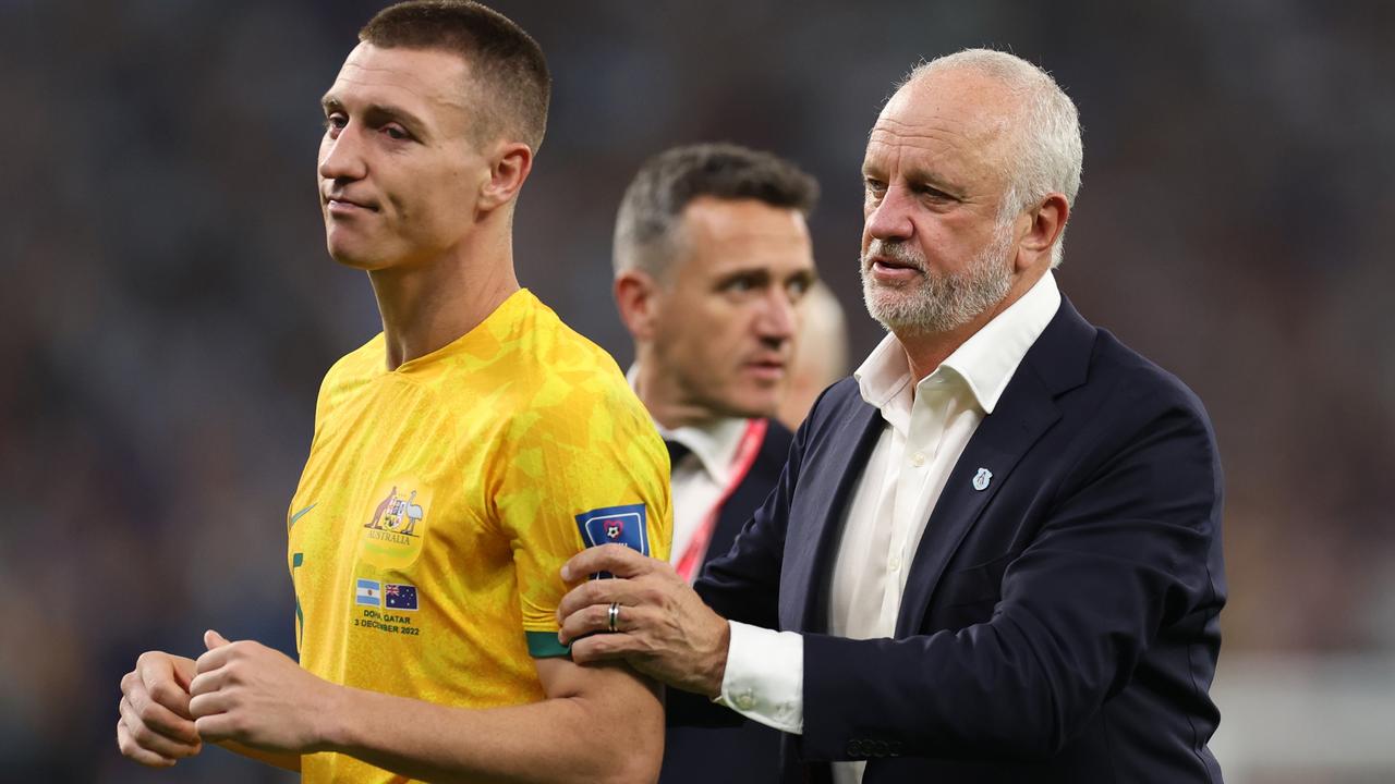 Mitchell Duke of Australia is consoled by Graham Arnold