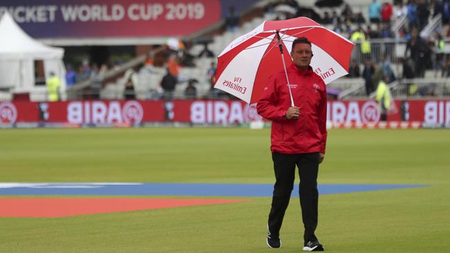 An umpire walks back after inspecting the field prior to suspension of the Cricket World Cup semi-final match between India and New Zealand for the day due to rains at Old Trafford in Manchester, England, Tuesday, July 9, 2019. (AP Photo/Aijaz Rahi)