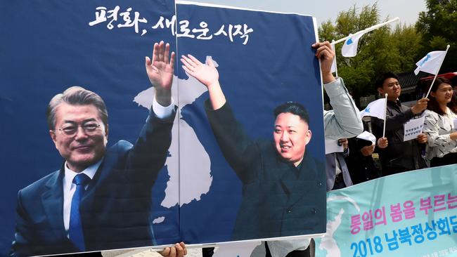 South Koreans hold up placards of South Korean President Moon Jae-In and North Korean leader Kim Jong-un during a rally welcoming the planned Inter Korean Summit in front of Presidential Blue House. Picture: Getty Images.