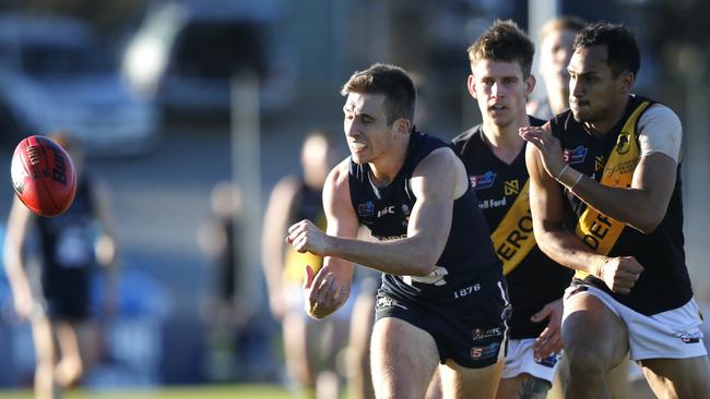 South v Glenelg. Joel Cross just getting a handball away from Marlon Motlop.. It was Marlons 100th game today. MUST CREDIT: CORY SUTTON