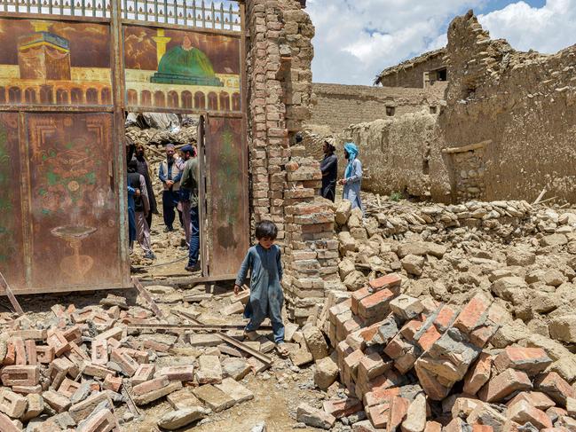 A child walks out from inside a gate of a house damaged by an earthquake in Bernal district, Paktika. Picture: AFP.