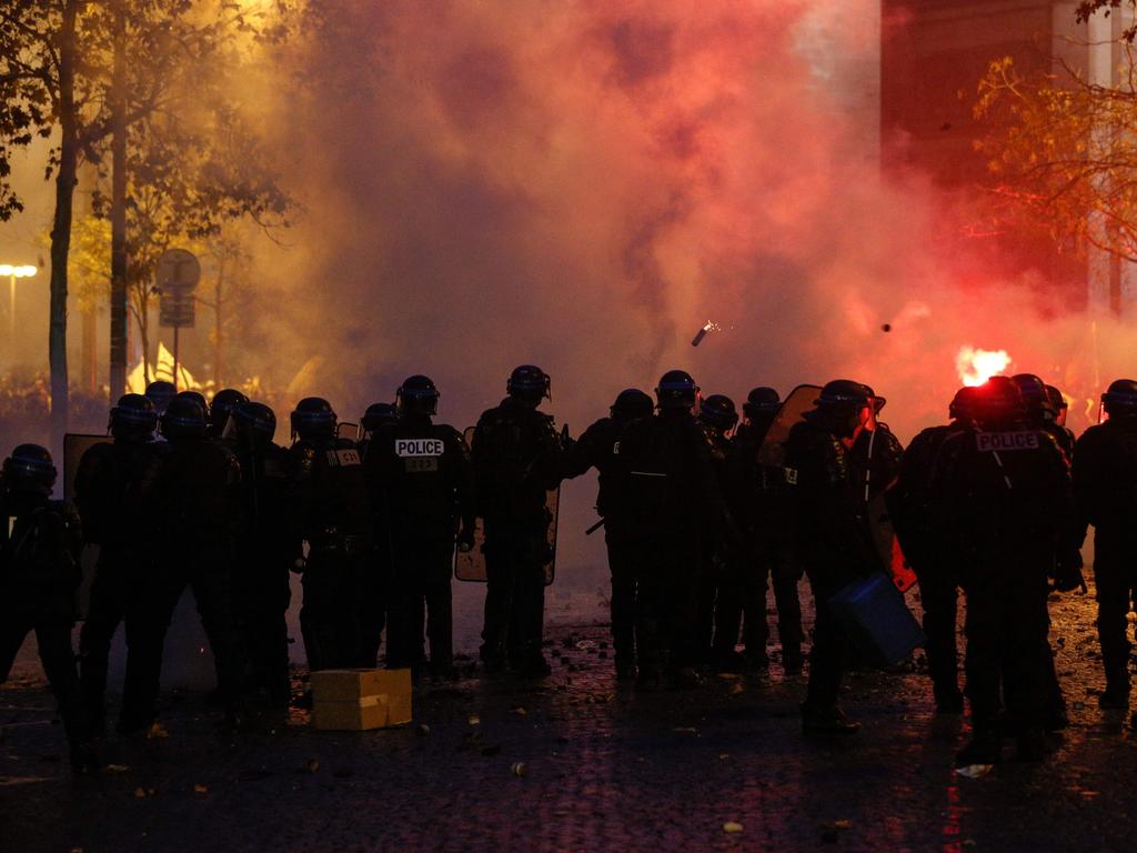 Riot police stand amidst smoke, as they face demonstrators during a protest of Yellow vests (Gilets jaunes) against rising oil prices and living costs, near the Arc of Triomphe. Picture: AFP