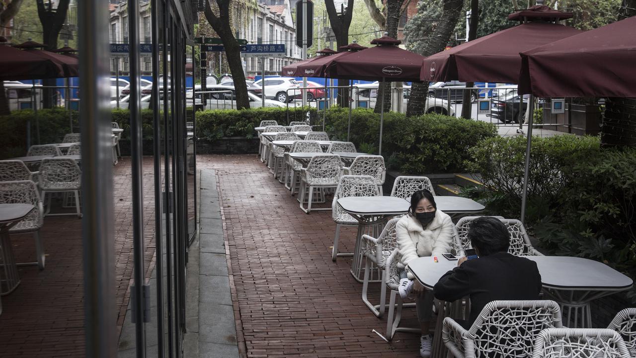 Two residents sit in an empty restaurant on April 1 in Wuhan. The government stipulates that residents with a green health code can go out. Picture: Getty Images