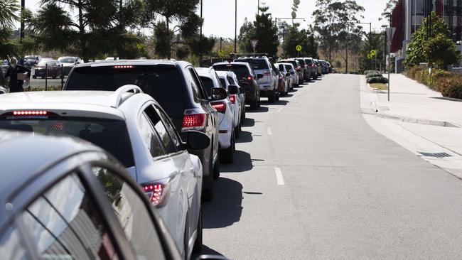 A growing line of cars waiting to access a testing station set-up at Orion Springfield Central Shopping Centre last week. Picture: Attila Csaszar