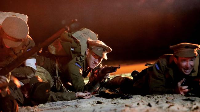 Men lay among the fallen on the sand during the re-enactment. Pic by Luke Marsden.