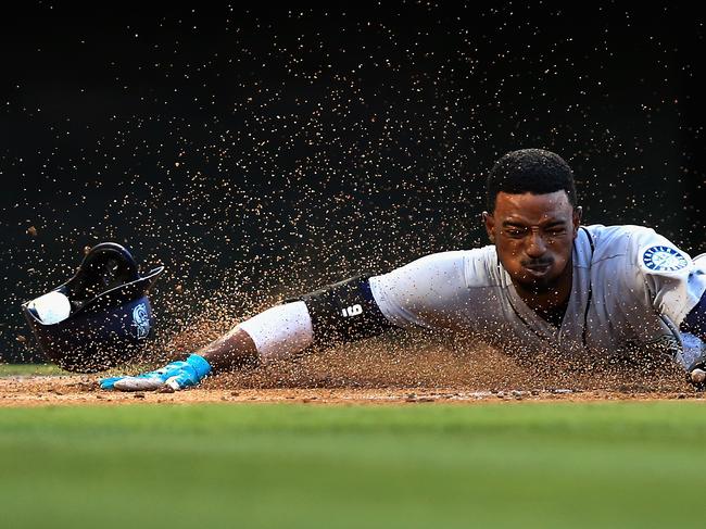 Dee Gordon #9 slides safely at home scoring on an RBI single hit by Kyle Seager #15 of the Seattle Mariners during the first inning of a game against the Los Angeles Angels of Anaheim at Angel Stadium on July 12, 2018 in Anaheim, California. (Photo by Sean M. Haffey/Getty Images)