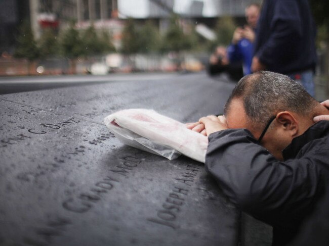 Eddie Reyes is comforted in 2011 while remembering 15 of his colleagues in the New York Police Department Emergency Service Unit who were killed on September 11, 2001. Picture: Spencer Platt/Getty Images