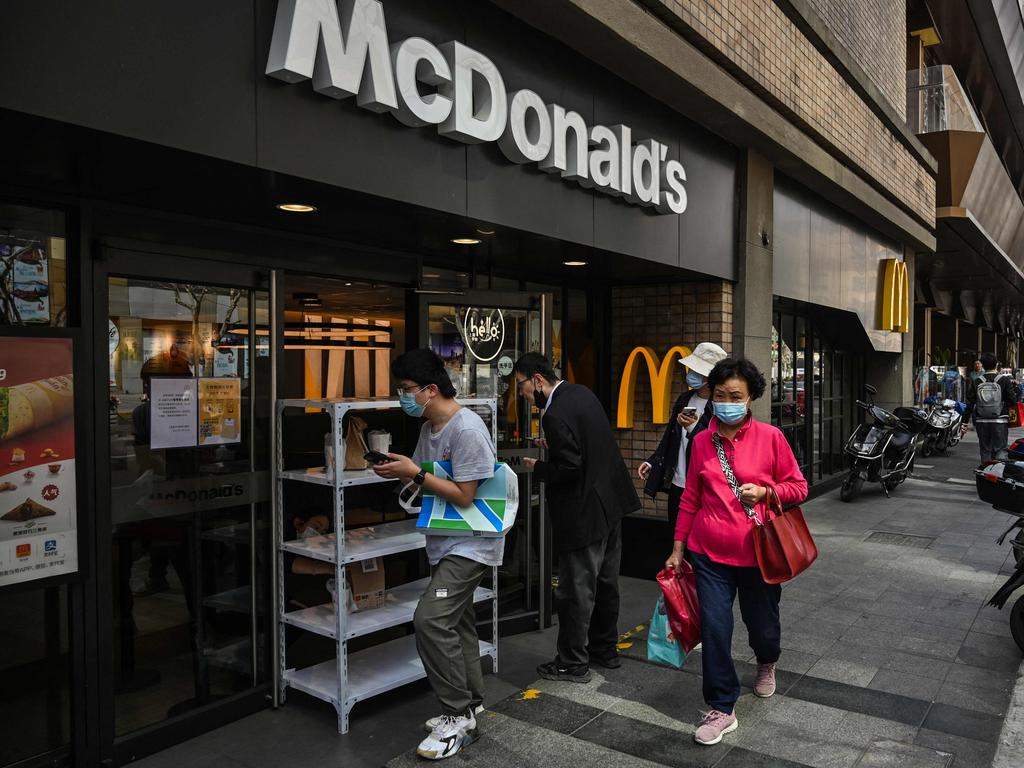 People wait for there food that is delivery at the entrance of a McDonald’s as a measure against the coronavirus in Shanghai. Picture: AFP