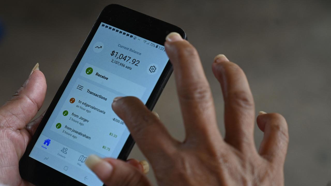 A woman uses a bitcoin app at a store in El Zonte, La Libertad, El Salvador on September 4, 2021. Picture: Marvin Recinos/AFP