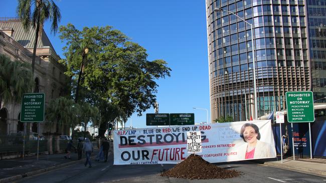 A banner featuring a picture of Jackie Trad was placed near a pile of manure dropped outside Parliament House by Extinction Rebellion activists. Picture: Nathan Edwards