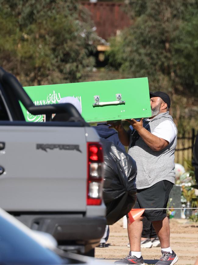 Iskander’s coffin is unloaded at Rookwood Cemetery.