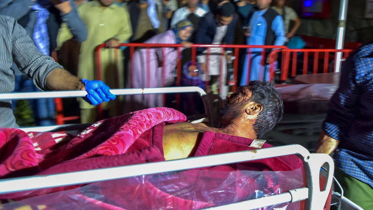 Medical and hospital staff bring an injured man on a stretcher for treatment after two powerful explosions outside the airport in Kabul. Picture: Wakil Kohsar/AFP