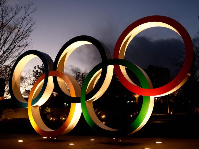 (FILES) This file photo taken on January 8, 2021 shows the Olympic Rings seen near the National Stadium, the main venue for the Tokyo 2020 Olympic and Paralympic Games, in Tokyo. - From the unprecedented coronavirus postponement to sexism scandals and a ban on overseas fans, the path to staging the Tokyo Olympics has been far from smooth, with 100 days until the opening ceremony on July 23, 2021. (Photo by Behrouz MEHRI / AFP)